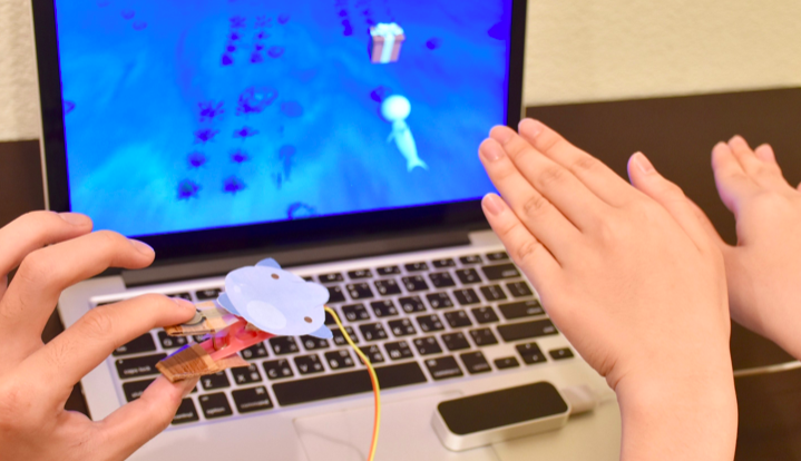 PinchFun is a cooperative game for parents and children to play together to train children's fine motor skills. This picture includes two main game controller: a clip and leap motion controller.